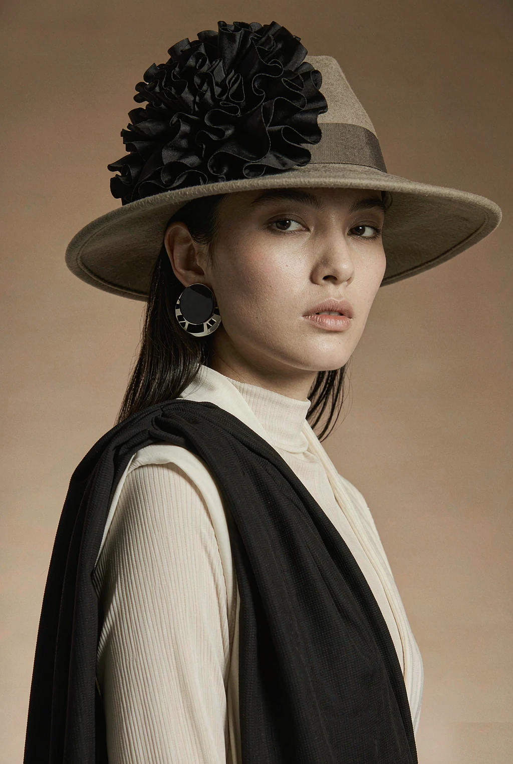 Woman wearing a wide brim hat in a warm neutral studio